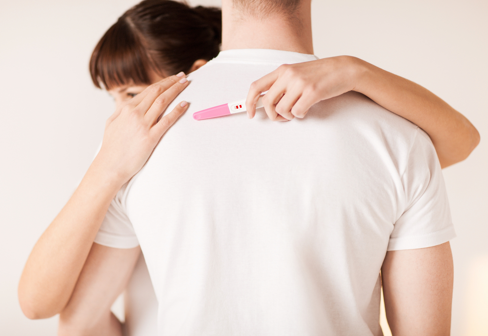 Close,Up,Of,Woman,With,Pregnancy,Test,Hugging,Man